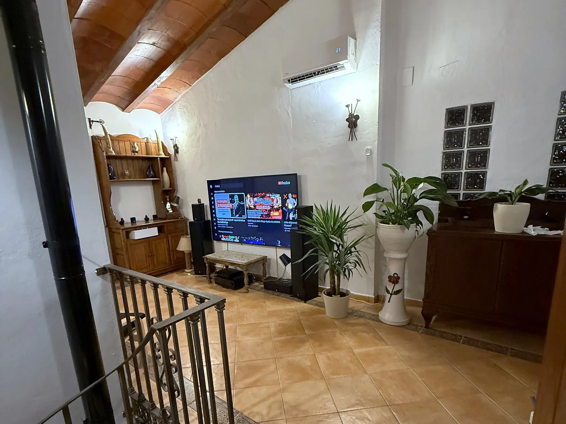 Salon z telewizorem pod drewnianym sufitem